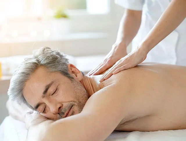 Un homme détendu reçoit un massage des épaules sur la table de massage.
